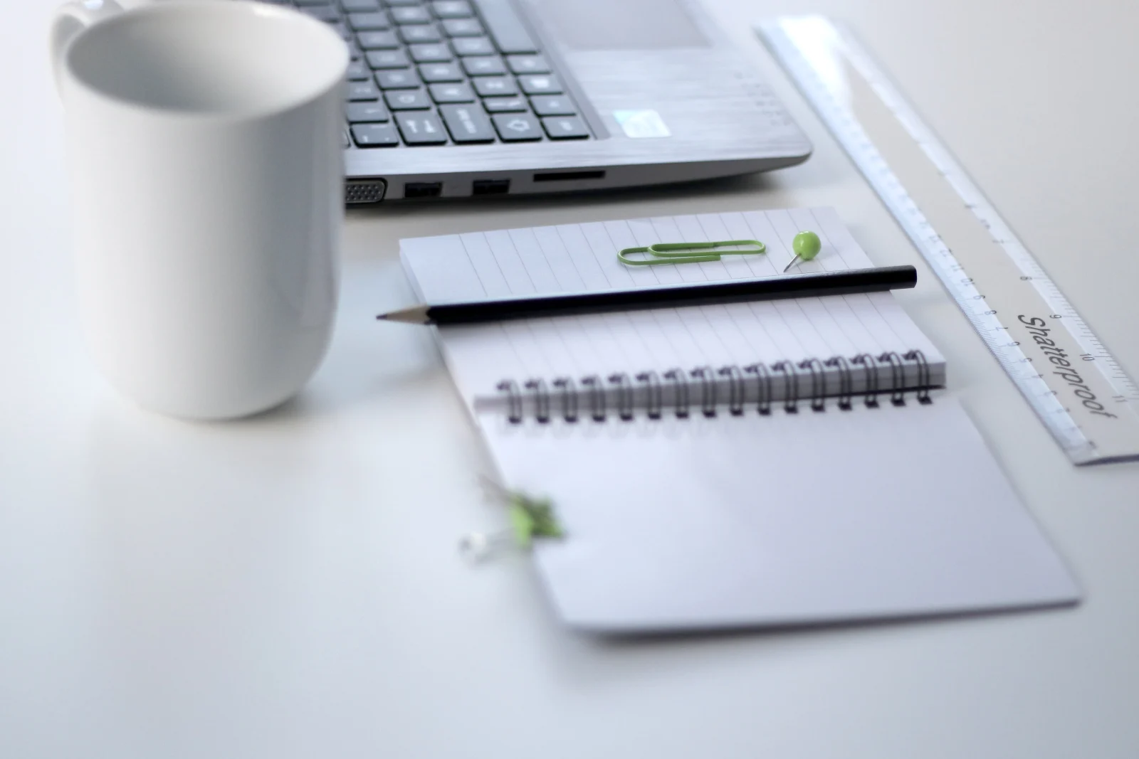 Laptop, carnet și creion pe birou, pregătite pentru completarea declarației Self Assessment online