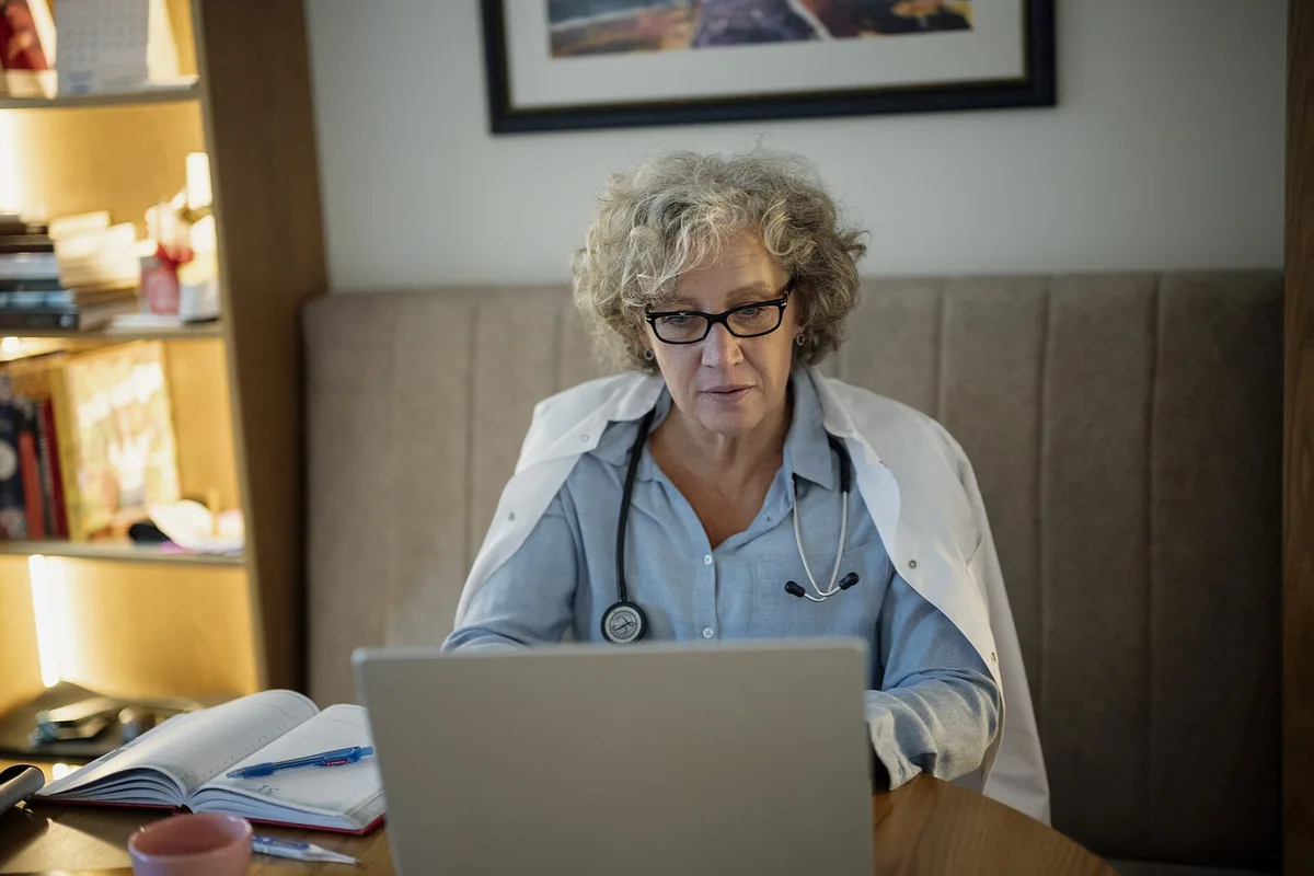 Medic care lucrează la laptop