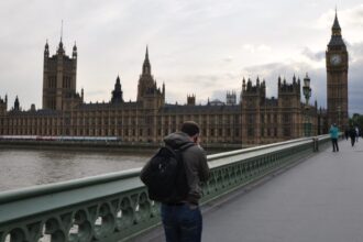 Bărbat pe Podul Westminster, cu Parlamentul britanic și Big Ben în fundal