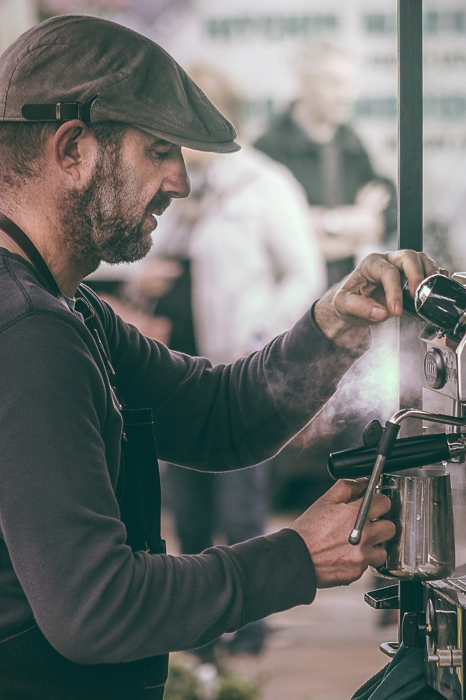 Barista care pregătește cafea la expresor, exemplu de job plătit cu salariul minim în UK