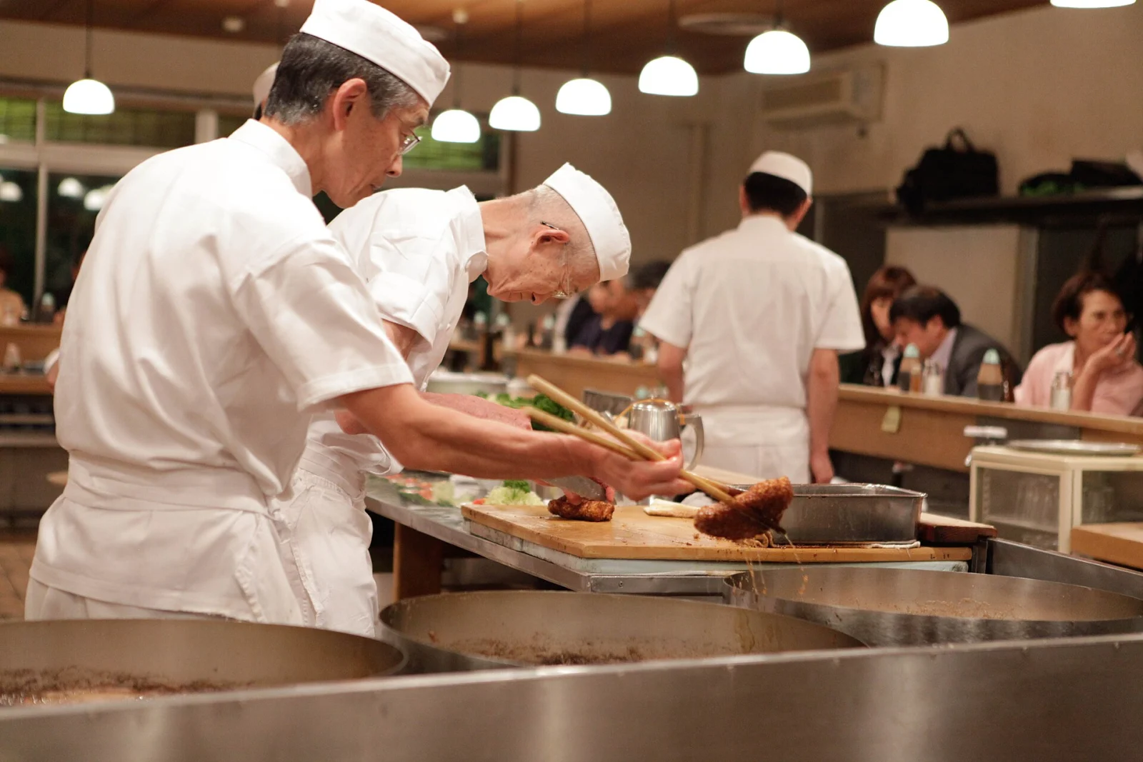 Bucătari la lucru în bucătăria unui restaurant, imagine pentru salariul minim în UK 2026
