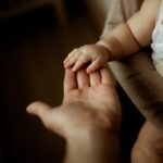 Mâna unui copil în palma unui părinte