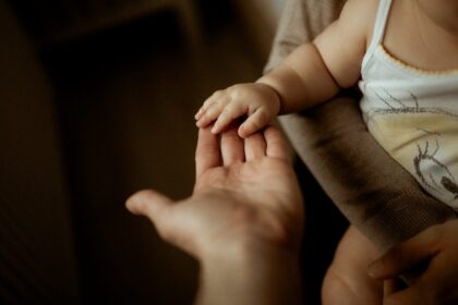 Mâna unui copil în palma unui părinte