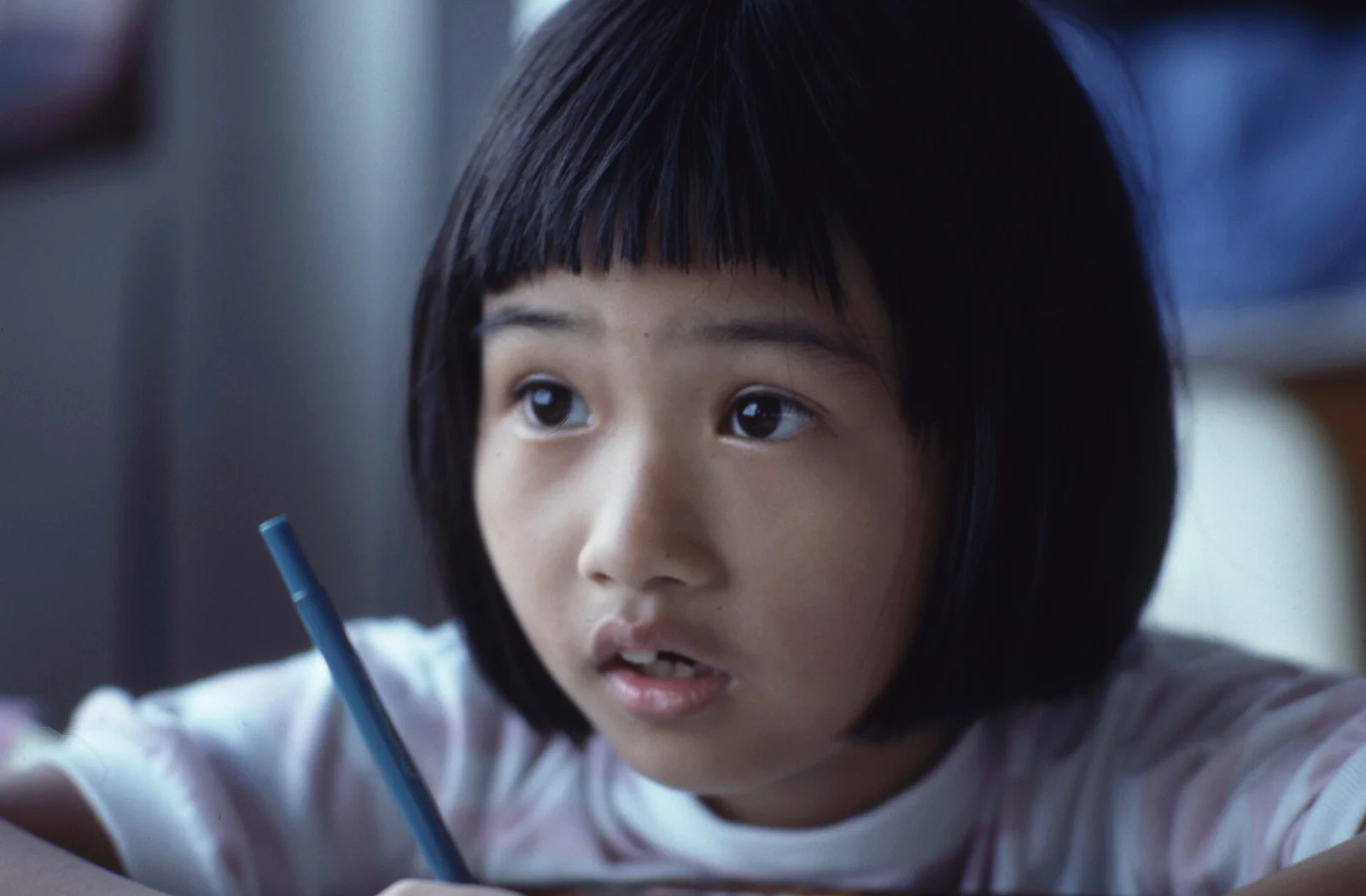 Fetiță care scrie cu creionul la teme, la un club de după școală plătit prin Tax-Free Childcare