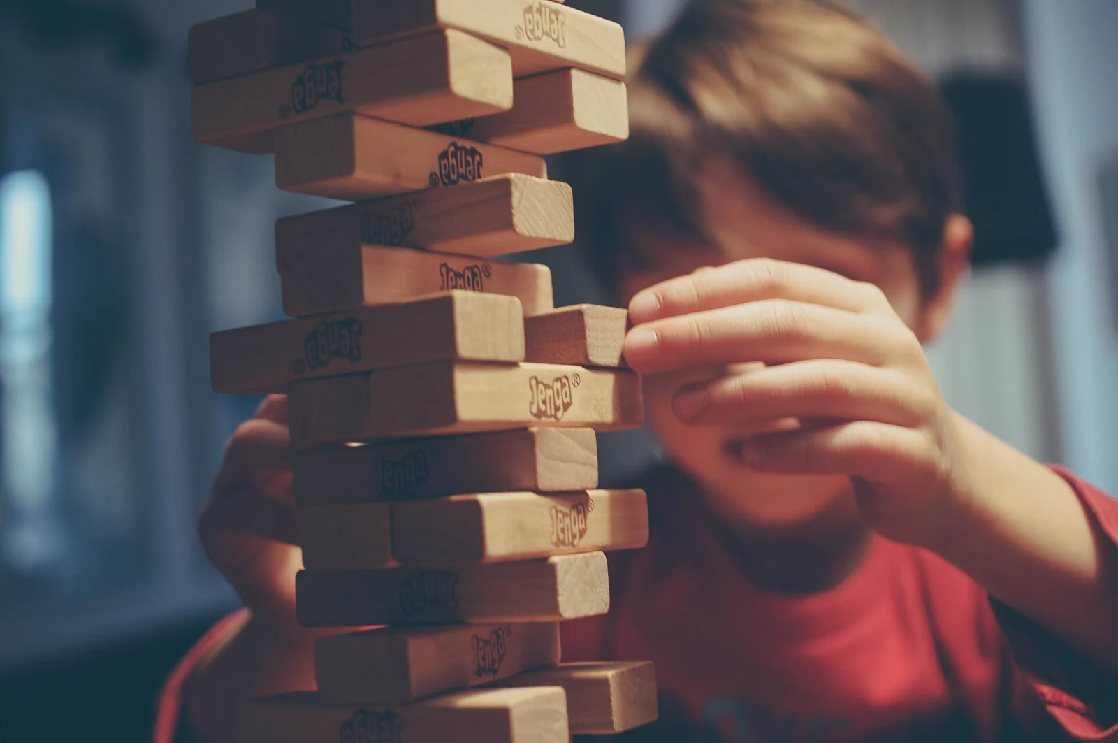 Băiat de școală primară care se joacă Jenga, copil eligibil pentru Tax-Free Childcare până la 11 ani