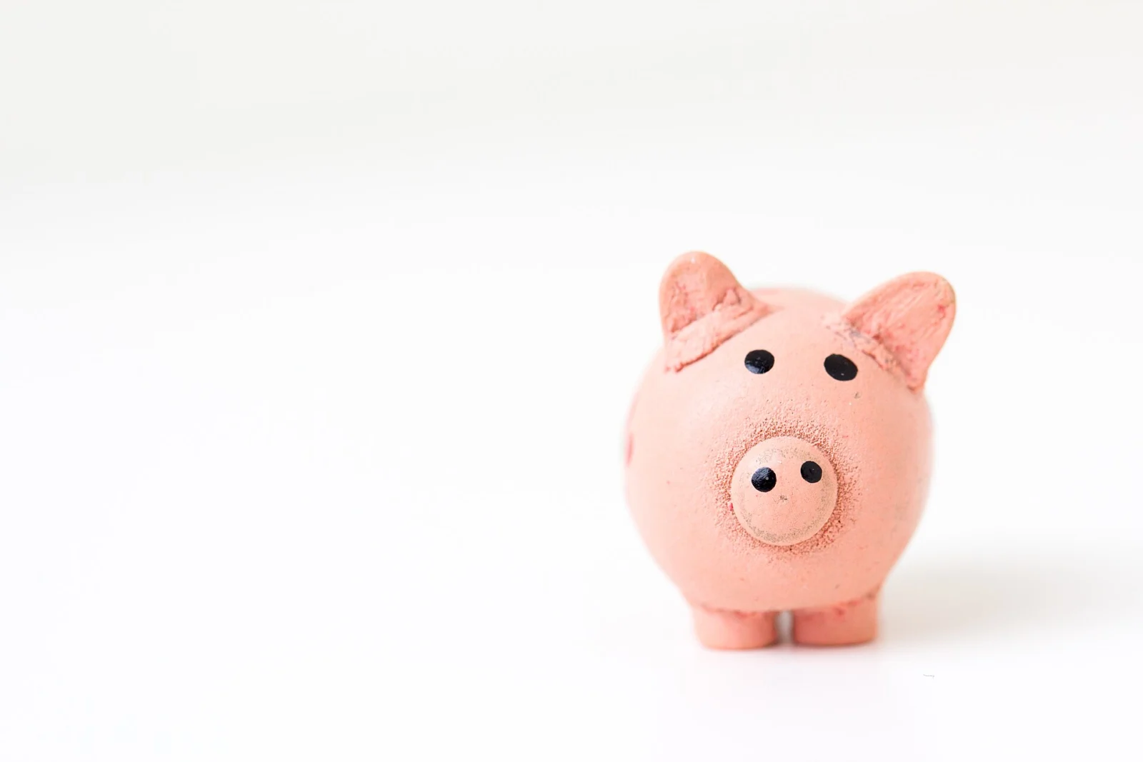 Pușculiță roz pe fundal alb, economii lunare într-un workplace pension