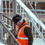 Muncitor cu cască și vestă reflectorizantă pe un șantier din Londra, angajat înscris într-un workplace pension